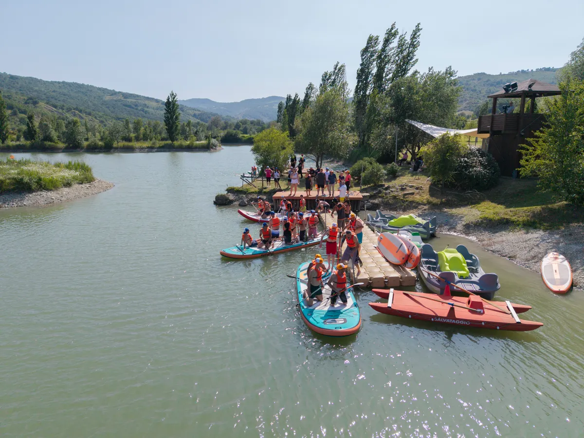 Partenza dal pontile di più squadre su tavole SUP giganti